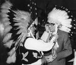 Mayor Ralph J. Perk is presented with an honorary Indian headdress by Van Dillard