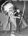 Native American Mohawk Young Deer gives Dick Myers a lesson in archery by unknown